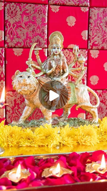 a statue of a person riding on top of a lion with flowers in front of red and gold wallpaper