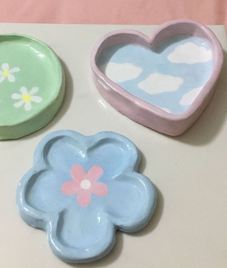 three cookie molds in the shape of heart, flower and cloud shapes on a table