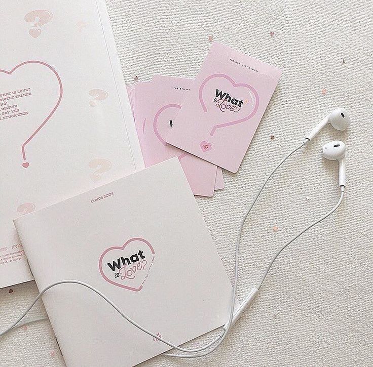 two notebooks and earphones are on the floor next to each other, with pink paper attached to them