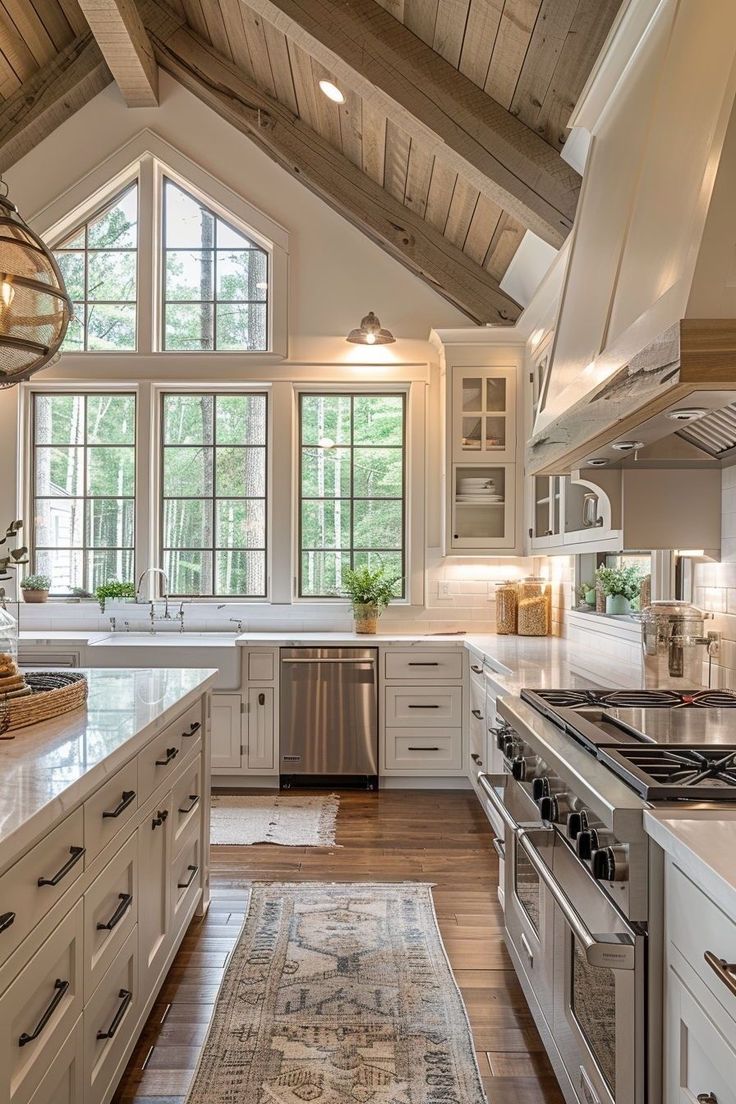 a large kitchen with white cabinets and wood floors, an area rug on the floor