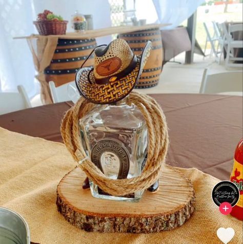 a glass bottle with a cowboy hat on top of it sitting on a wooden stand