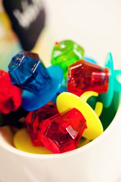 a white bowl filled with lots of different colored gummy bear candies on top of a table