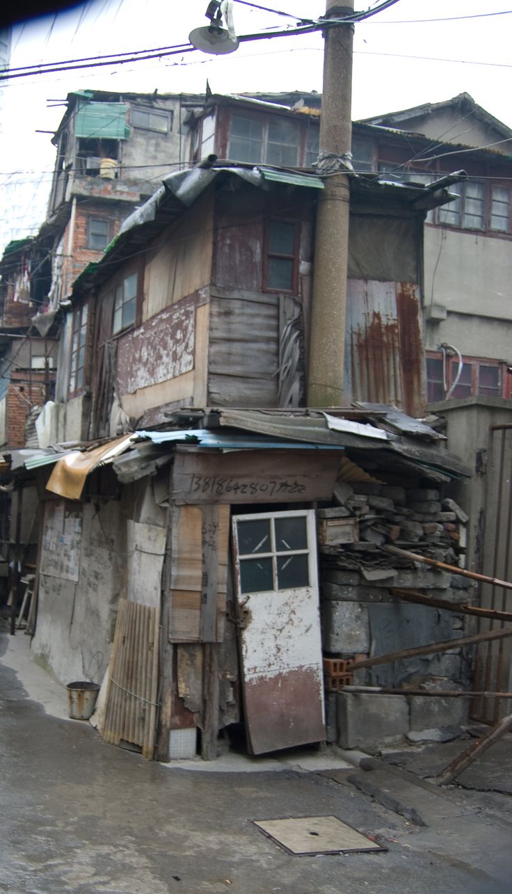 an old run down building in the middle of a street