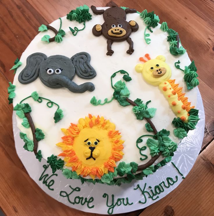 a birthday cake decorated with animals, giraffes and lions