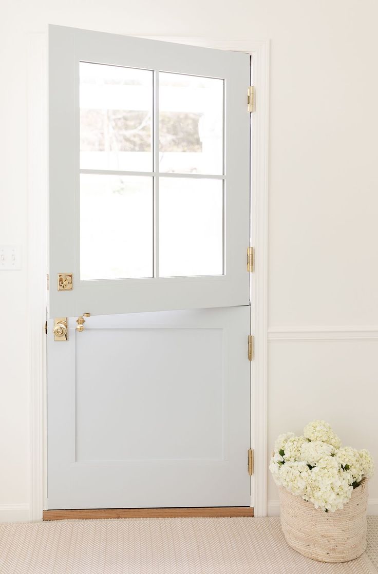 a vase with flowers sitting in front of a white door