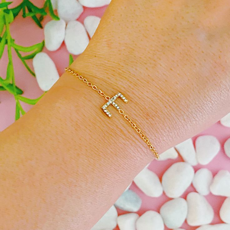 This Dainty Sparkle Initial Bracelet adds a touch of sparkle and personalization to your look. Crafted with a slim and dainty chain, the adjustable sliding closure makes it easy to put on and get the right fit. Perfect for wearing alone or layering with other bracelets, it adds just the right amount of sparkle.Reversible with plain gold side or sparkly CZ side.Approximately, can fit up to 9 inch perimeter18k gold plated Stainless Steel, tarnish and water resistantCubic ZirconiaLead and Nickel fr Bracelet Initial, Hair Setting, Dainty Chain, Initial Bracelet, Scrunchie Hairstyles, Steel Jewelry, Stainless Steel Jewelry, Hair Accessories Headbands, Headband Hairstyles