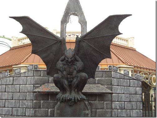 a black and white photo of a gargoyle sitting on top of a building