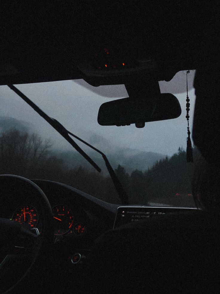 the dashboard of a car with fog in the background