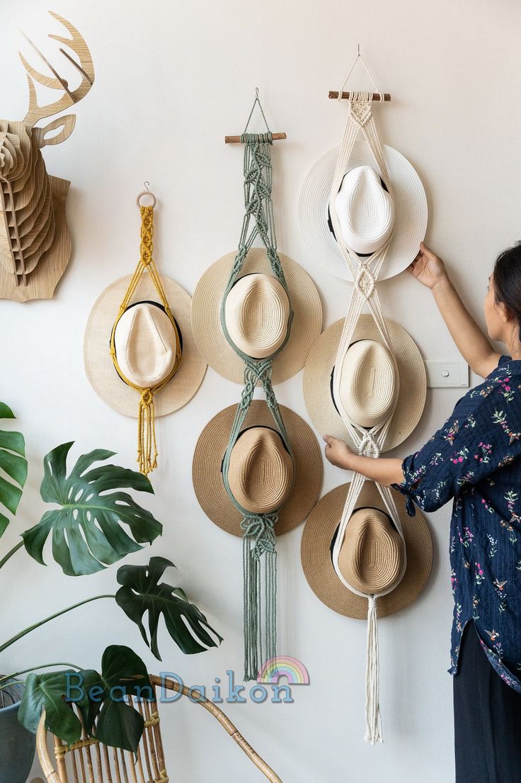 a woman is hanging hats on the wall