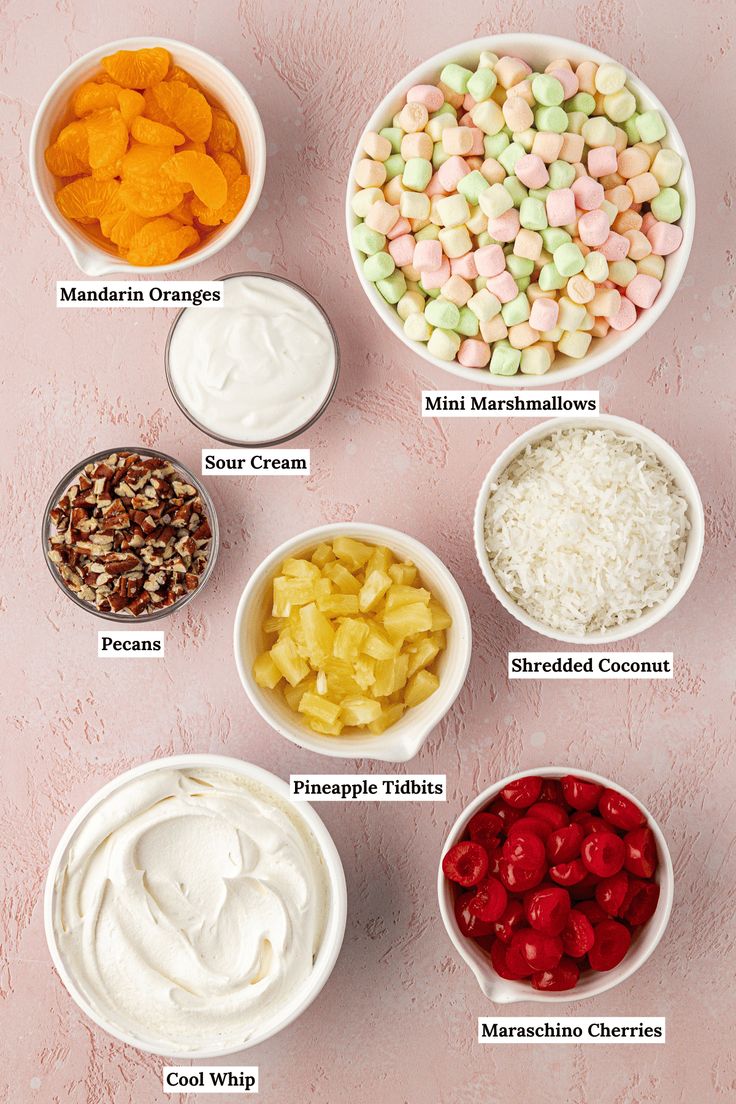 bowls filled with different types of food on top of a pink surface, all labeled in the following words