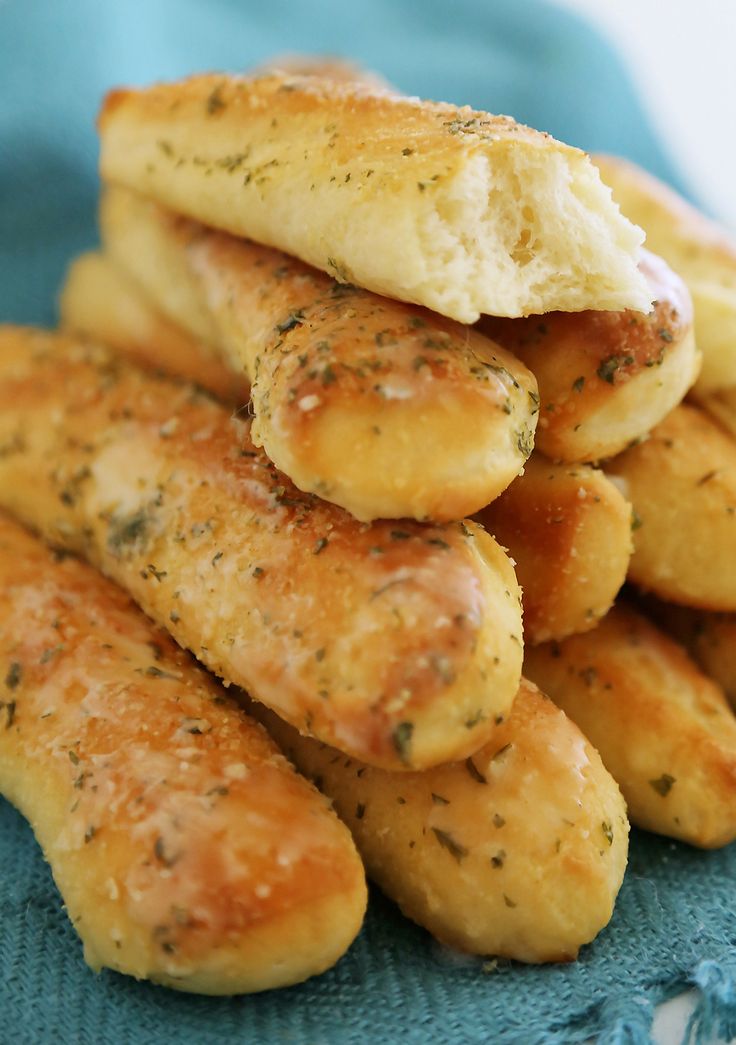 some bread sticks stacked on top of each other in a blue dishclothed bowl