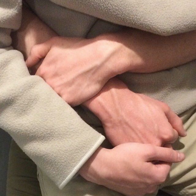 a person wrapped in a blanket with their hands on each other's chests