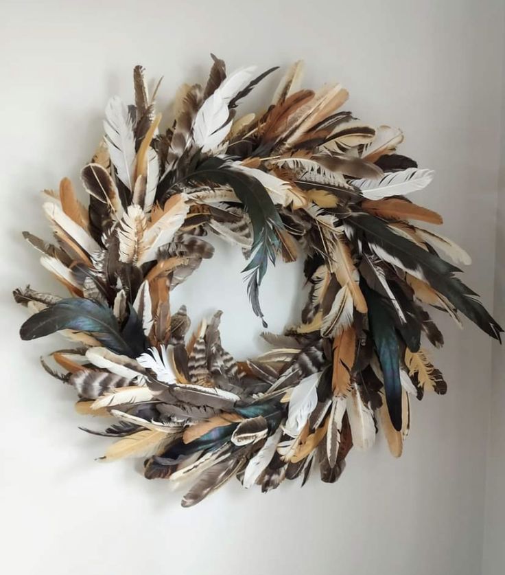 a wreath made out of feathers is hanging on the wall