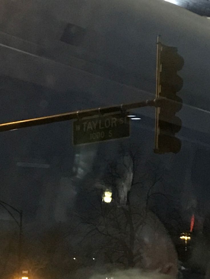 a traffic light hanging from the side of a metal pole next to a street sign