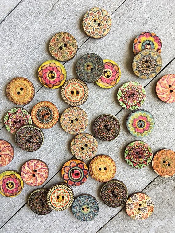 many different colored buttons on a wooden surface