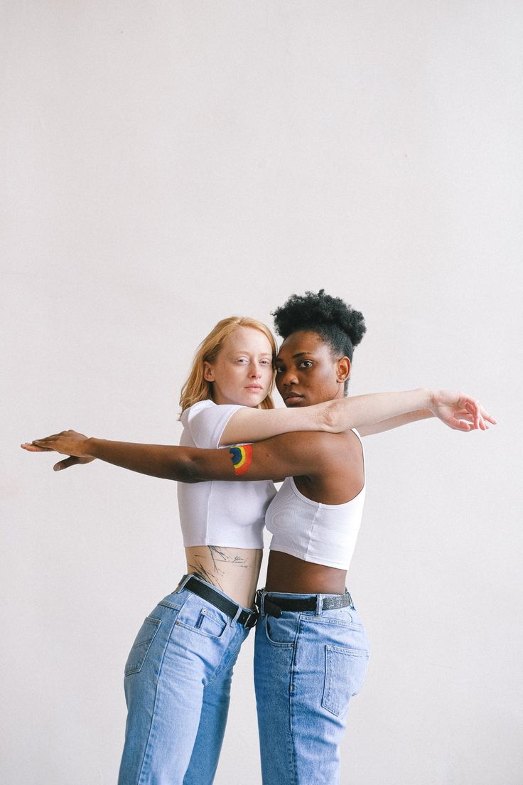 two young women are hugging and posing for the camera