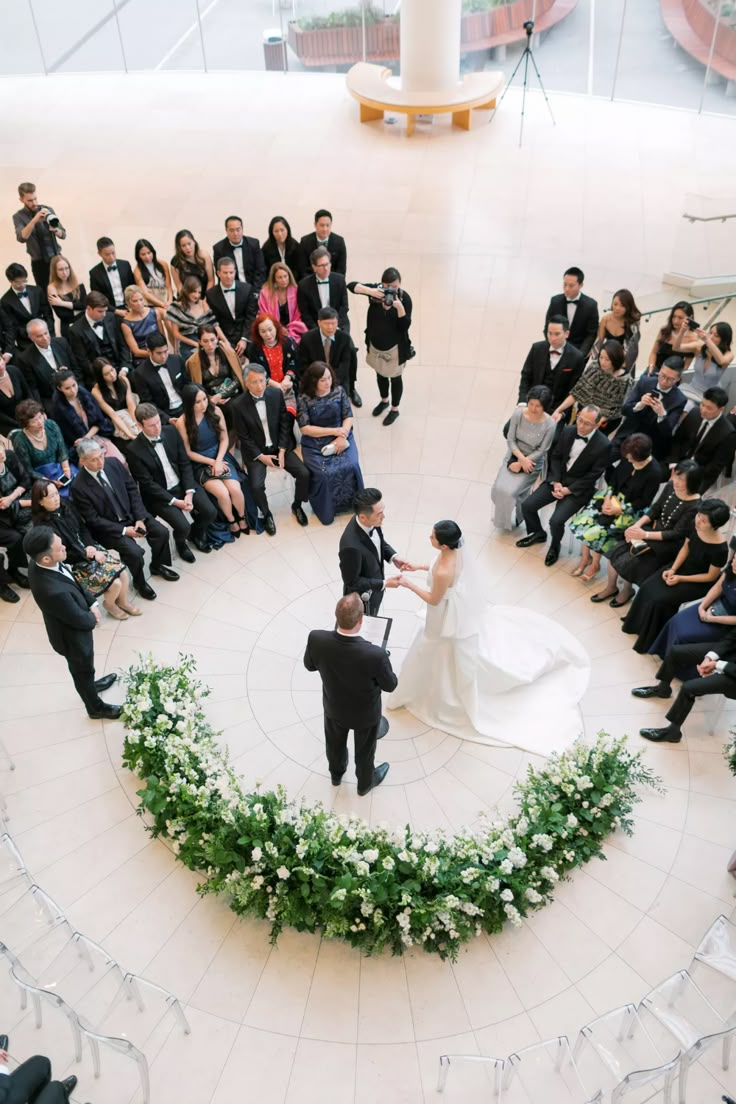 an overhead view of a bride and groom standing in front of their wedding ceremony guests