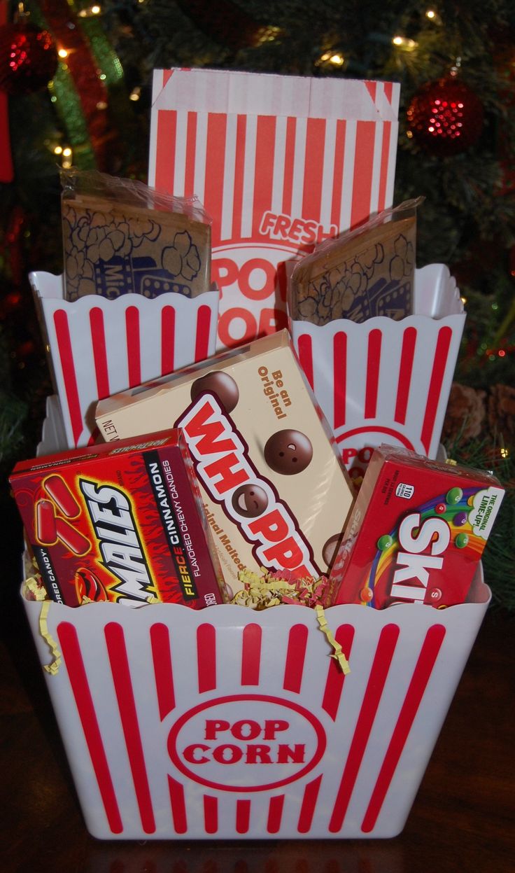 a popcorn box filled with candy and chocolates next to a christmas ornament