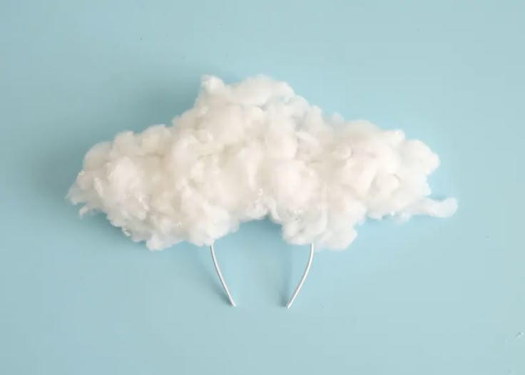 there is a cloud made out of cotton on top of the blue wall and it looks like something from above