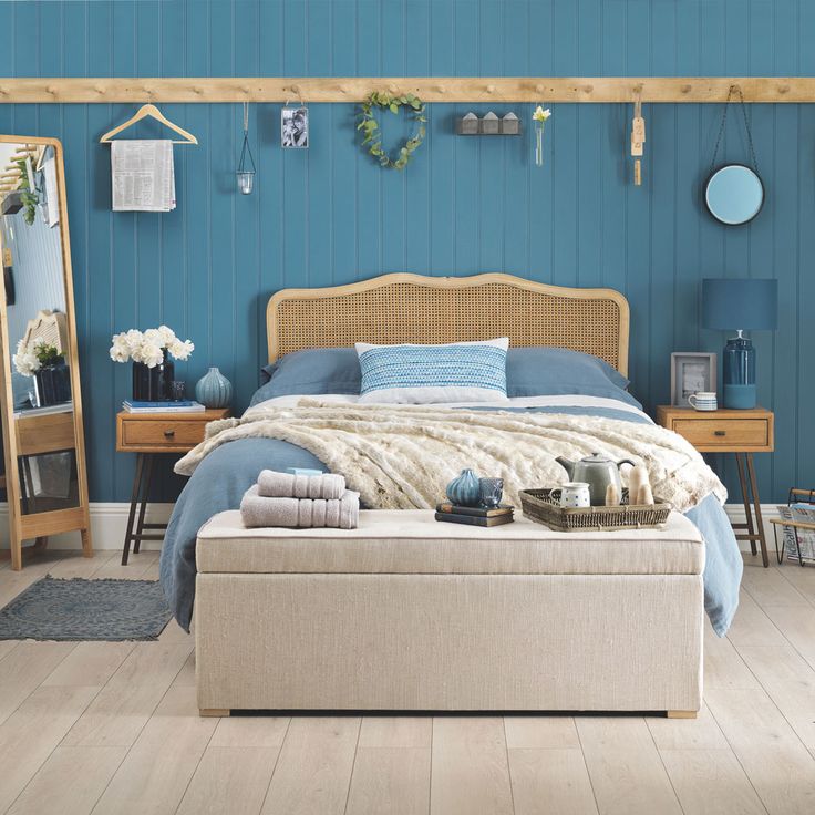 a bedroom with blue walls and furniture in it