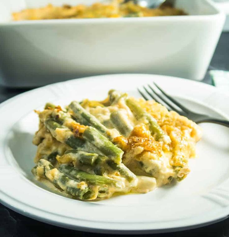 a white plate topped with an egg casserole next to a bowl of food