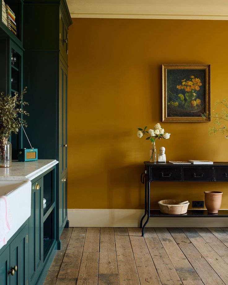 a room with yellow walls and wooden floors, painted in farrowe green paint