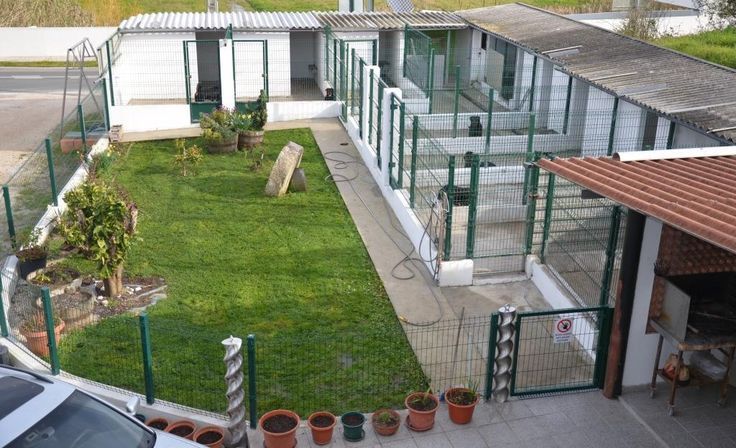 an aerial view of a building with green grass and potted plants in the yard