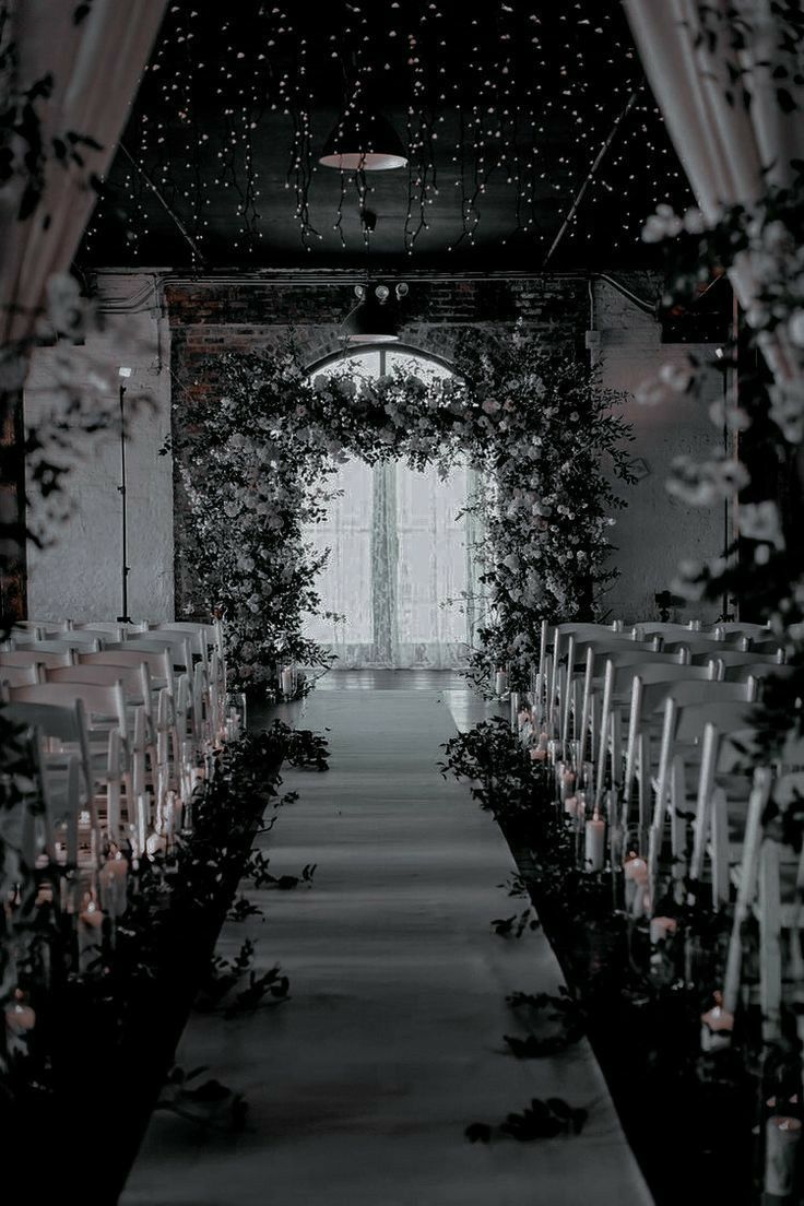 the aisle is lined with candles and greenery for an outdoor wedding ceremony in black and white