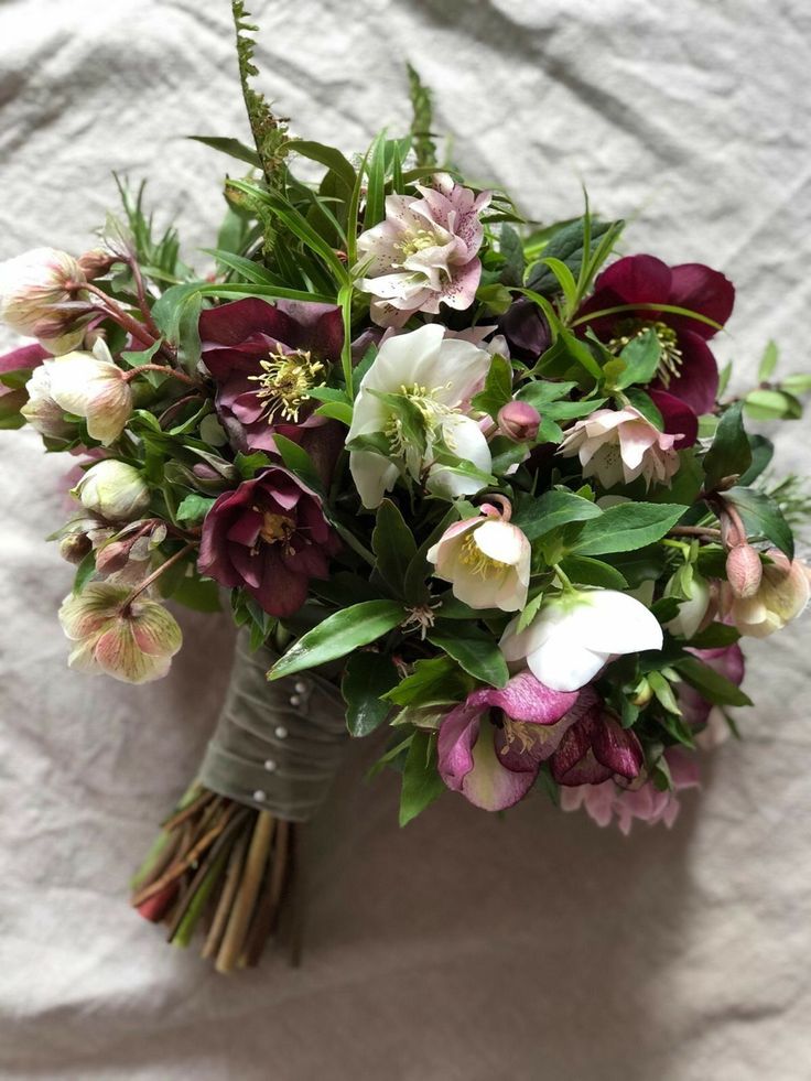 a bouquet of flowers sitting on top of a white sheet