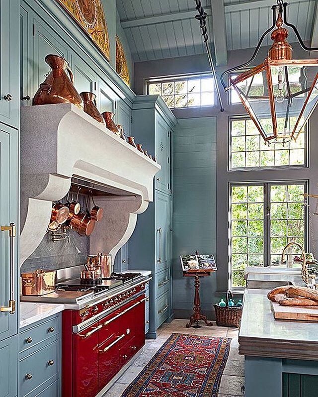 a kitchen with blue walls and red cabinets