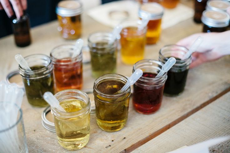 several jars filled with liquid sitting on top of a wooden table