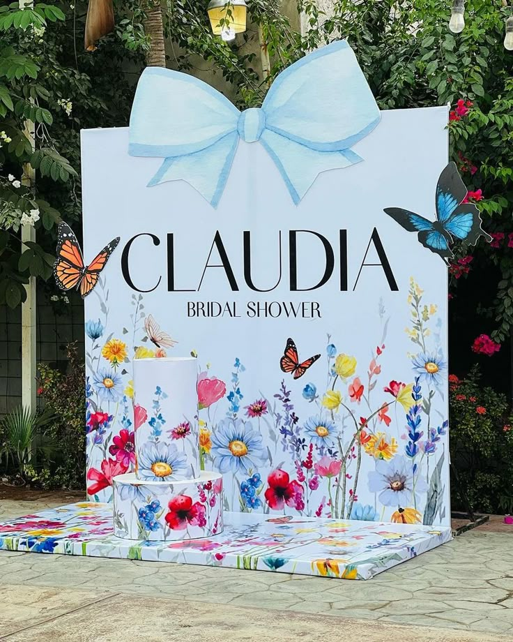 a sign that says claudia bridal shower with flowers and butterflies in front of it