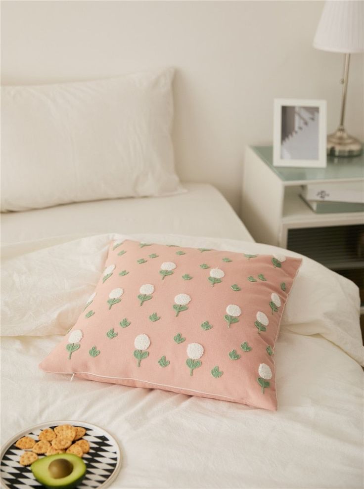 a bed with a plate of food on top of it next to a night stand