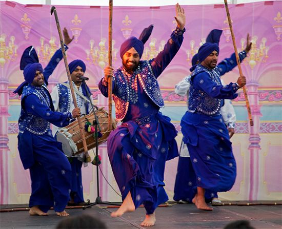 a group of people that are standing on a stage with some sticks in their hands