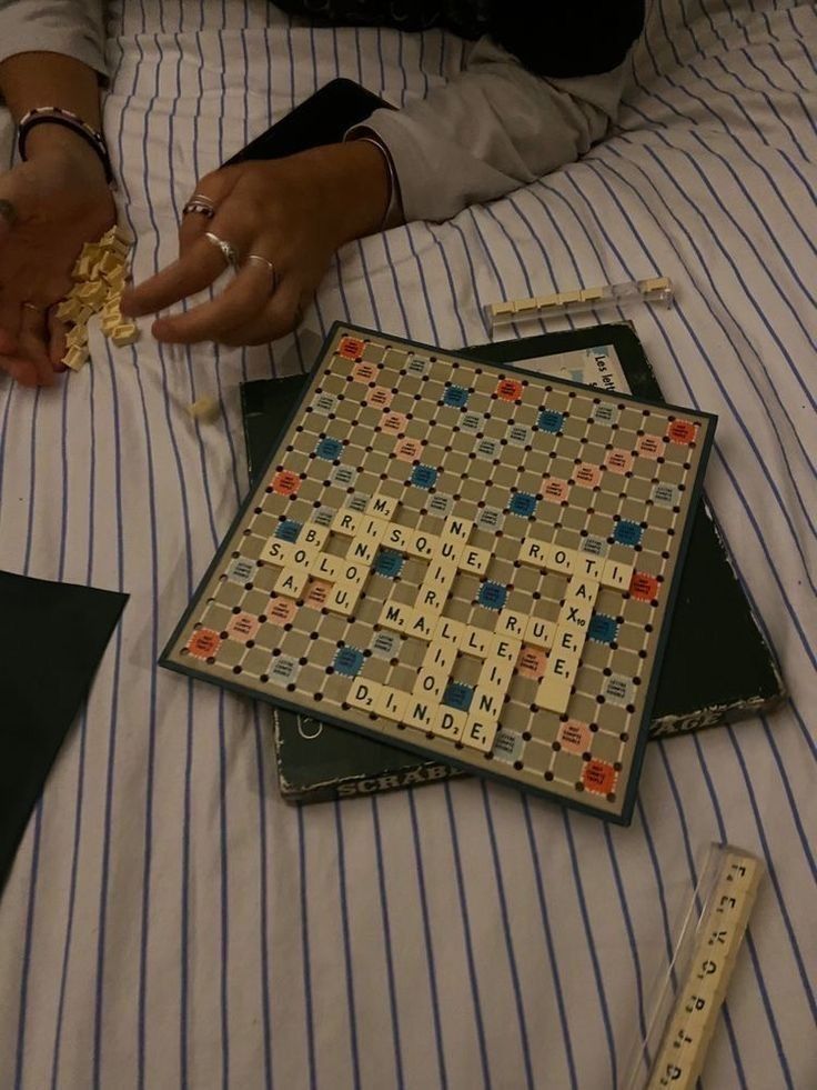 a person is laying on a bed with several pieces of scrabble