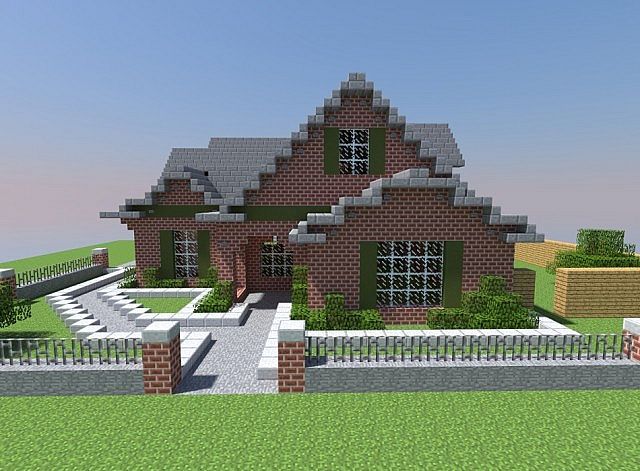 a large brick house sitting on top of a lush green field