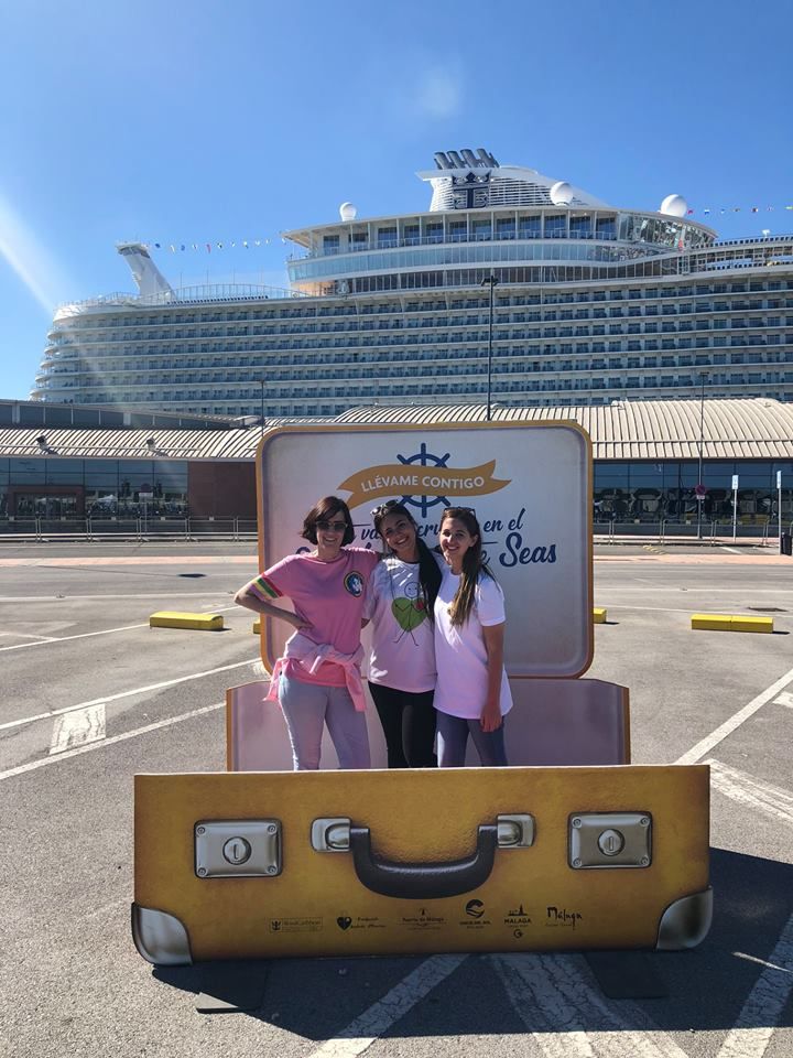 three girls are standing in front of a suitcase