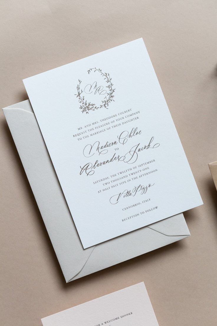 the wedding stationery is laid out on top of each other, including two envelopes