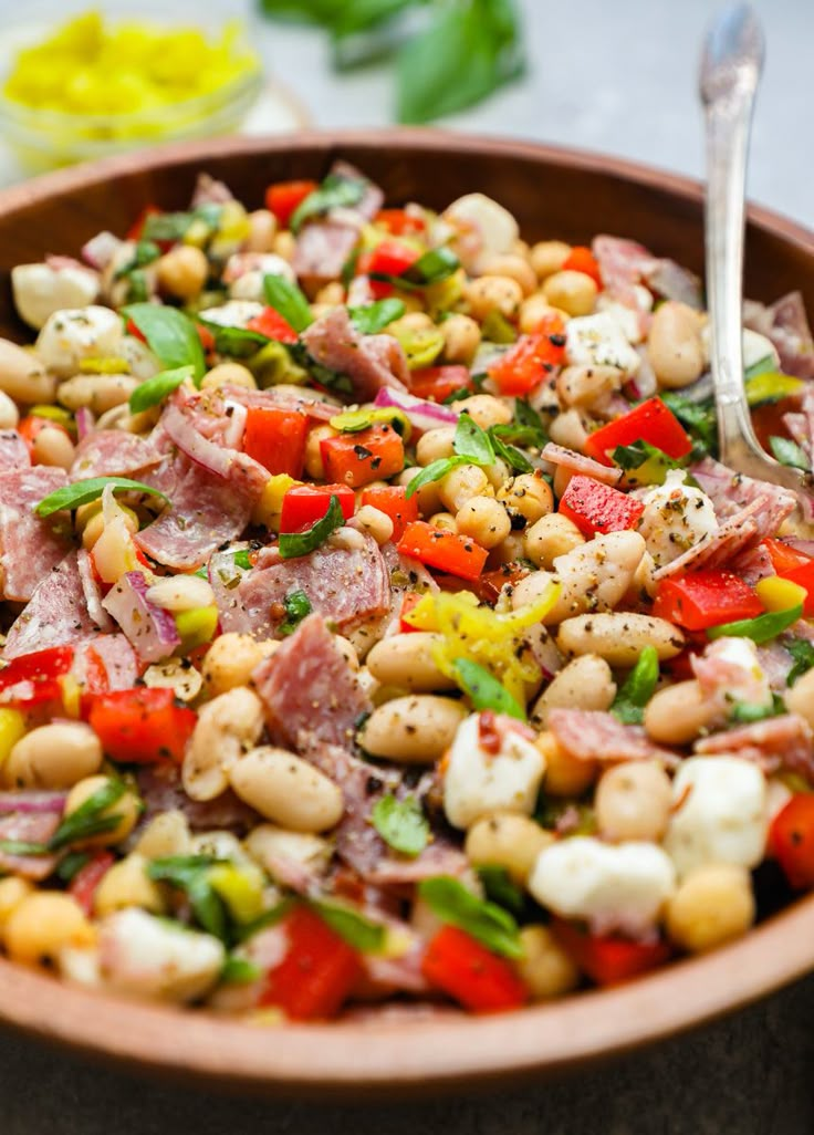 a large bowl filled with lots of different types of food on top of a table