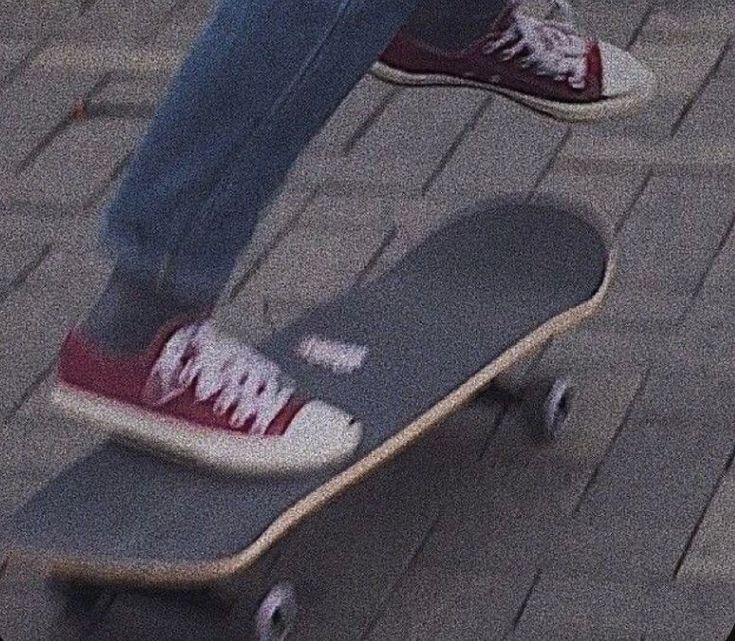 a person riding a skateboard down a brick sidewalk with their feet on the board