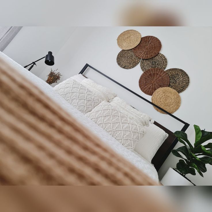 a bed sitting next to a plant in a bedroom