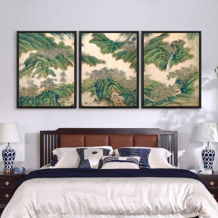 two paintings on the wall above a bed