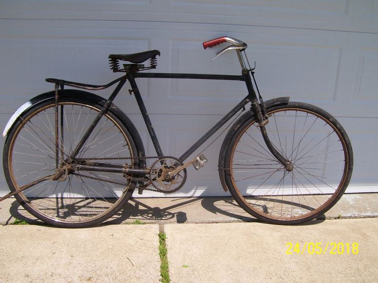 an old bicycle is parked in front of a garage door