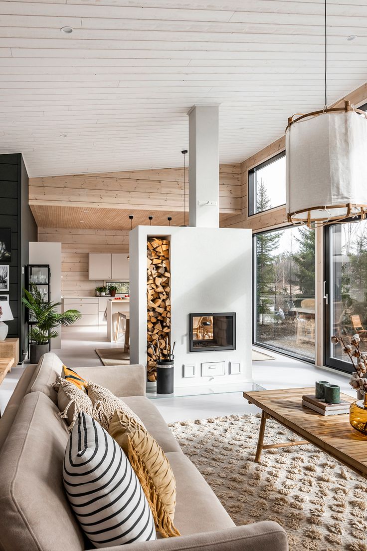 a living room filled with furniture and a fire place next to a window covered in wood