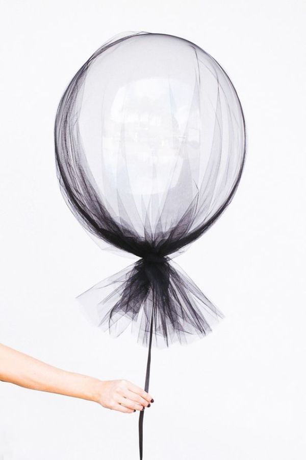 a person holding a black and white balloon