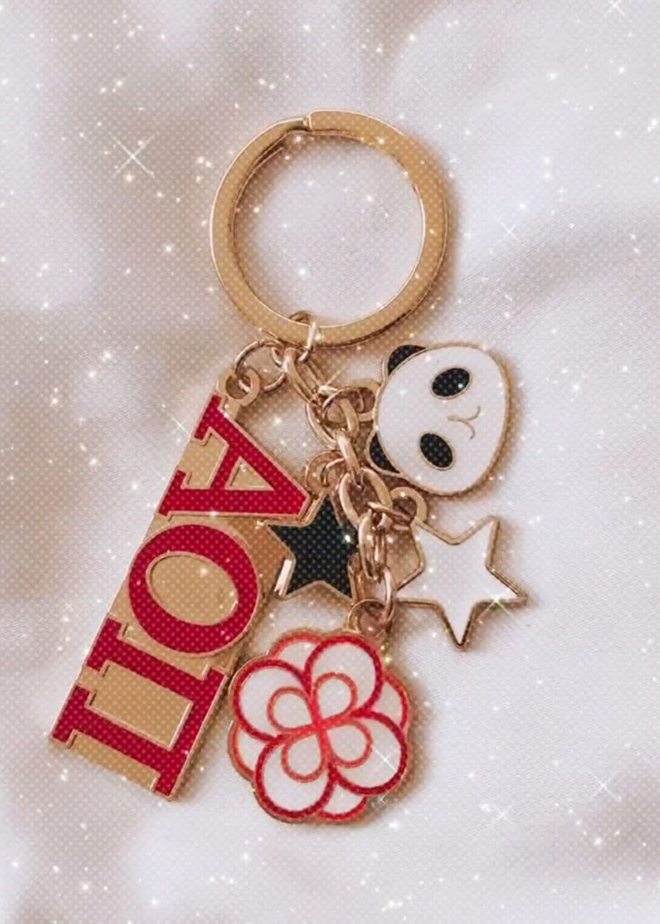 Carry a piece of sisterhood with you wherever you go with our stunning Alpha Omicron Pi Sorority Keychain featuring 5 cute and meaningful charms!  Included 5-charm keychain is a panda, white star, black star, official logo flower, and red AOII pendant. This beautiful keychain is crafted with high-quality gold-tone metal that exudes elegance and sophistication.  The centerpiece of the keychain is the Alpha Omicron Pi letters in striking red, showcasing your sorority pride in a bold and stylish way. But that's not all! Our keychain also includes a delightful panda charm, the official mascot of AOII. Two star charms add a touch of sparkle and represent the shining moments and accomplishments you share with your sorority sisters. Last but not least, we've included an AOII logo charm to add tha Alpha Omicron Pi Canvas, Sorority Ideas, Sorority Merch, Sorority Ornaments, Sorority Baskets, Sorority Decorations, Bid Day Gifts, Panda Charm, Sorority Themes