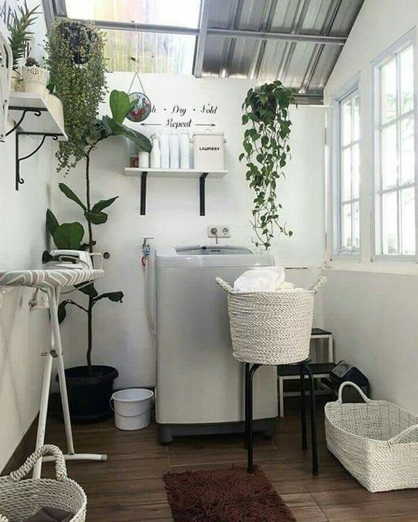 a small room with plants on the wall and a washing machine in the corner next to it