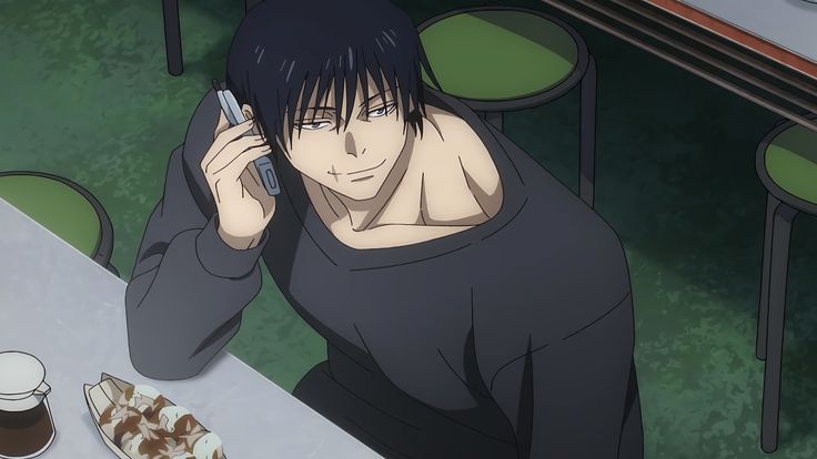 a person sitting at a table with a cell phone in their hand and food on the ground