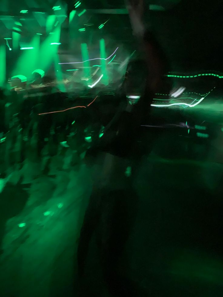 people are dancing in the dark with green lights