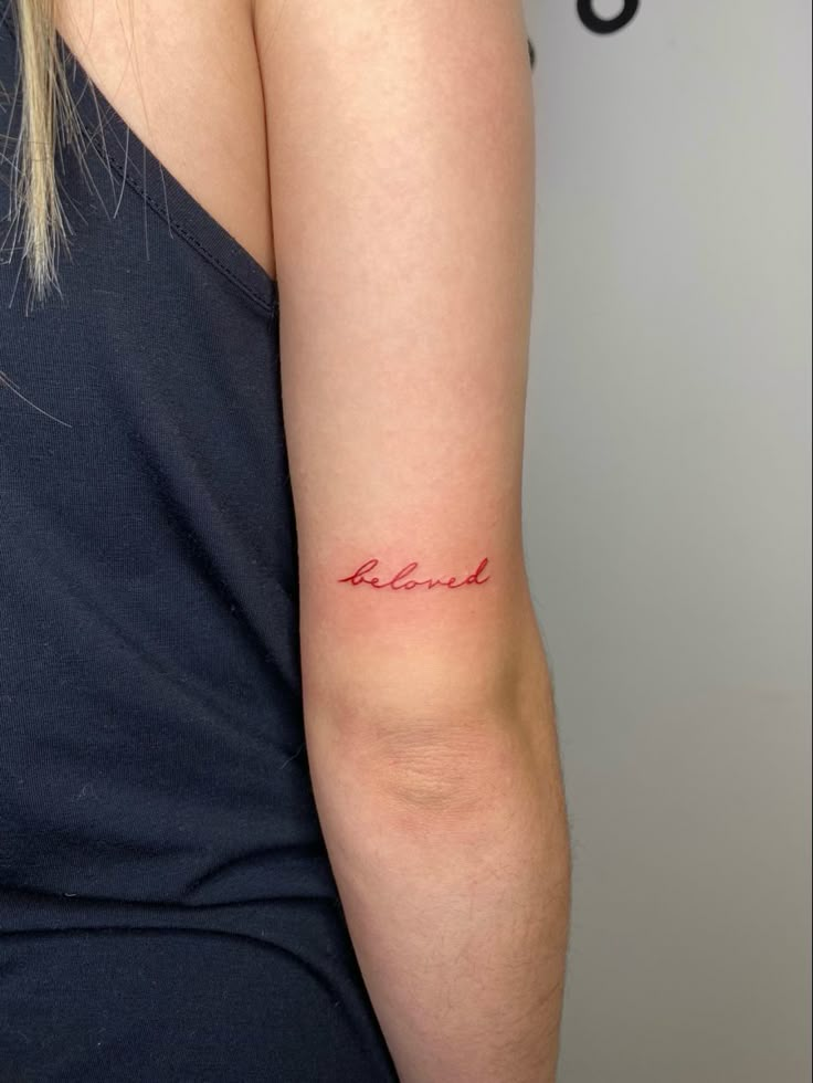 a woman with a tattoo on her arm that says, be kindl in red ink